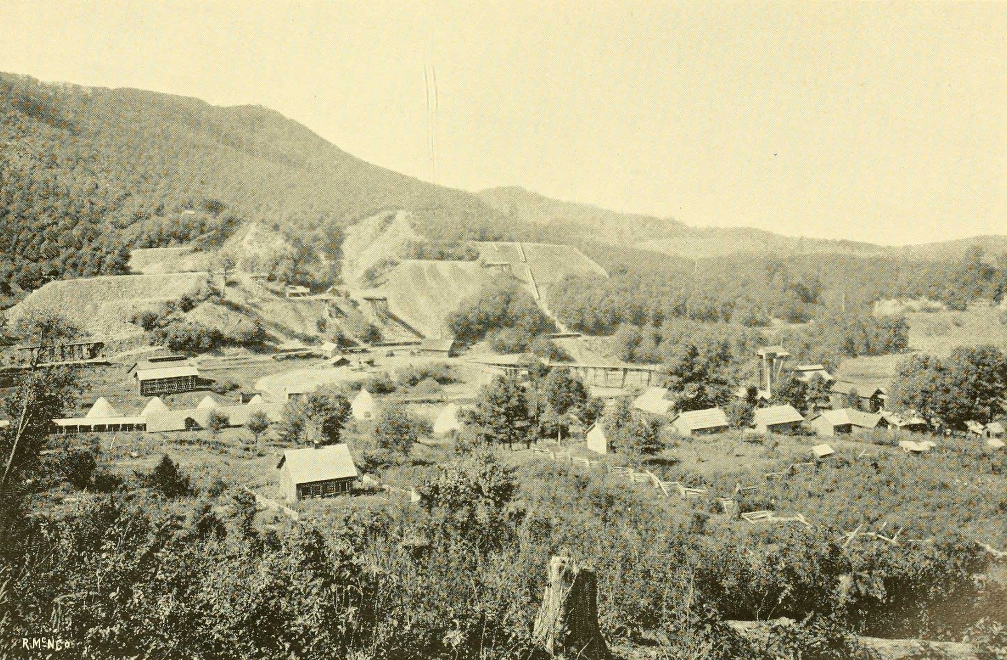 Black and white photo of the Cranberry Iron Mine, North Carolina, showing buildings on the landscape.
