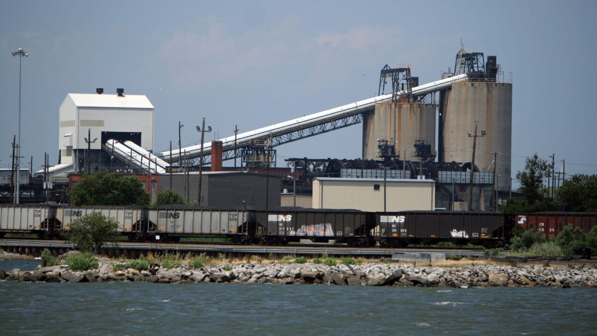 Photo of the Lamberts Point Coal Terminal. Railcars full of coal are in the foreground, with structures for transferring coal in the background.