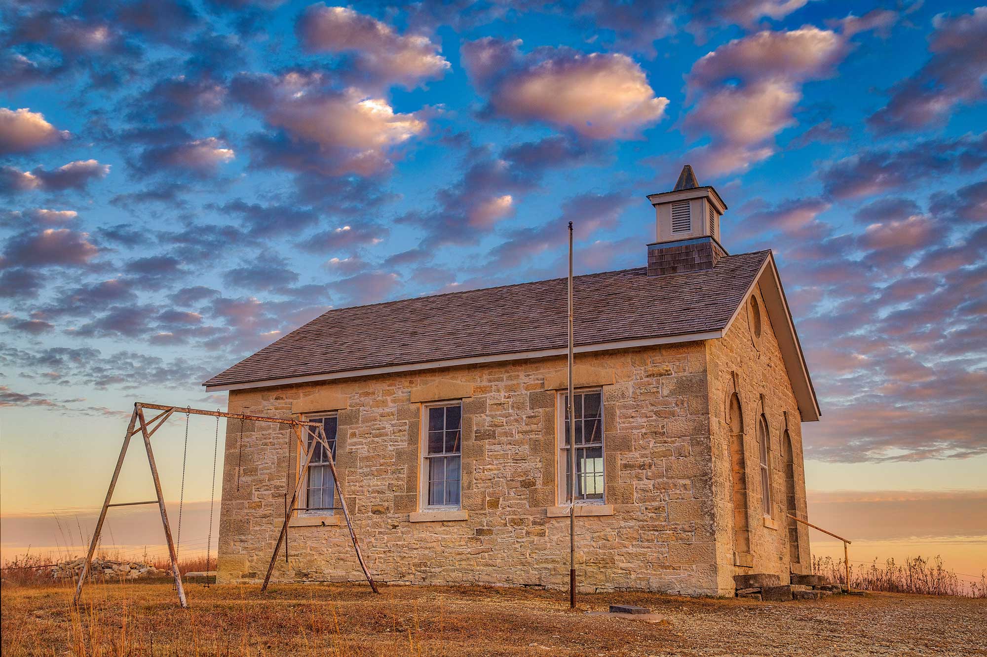 Photograph of the Lower Fox Creek Schoolhouse at Tallgrass Prairie National Preserve. The schoolhouse is built from Flint Hills limestone.