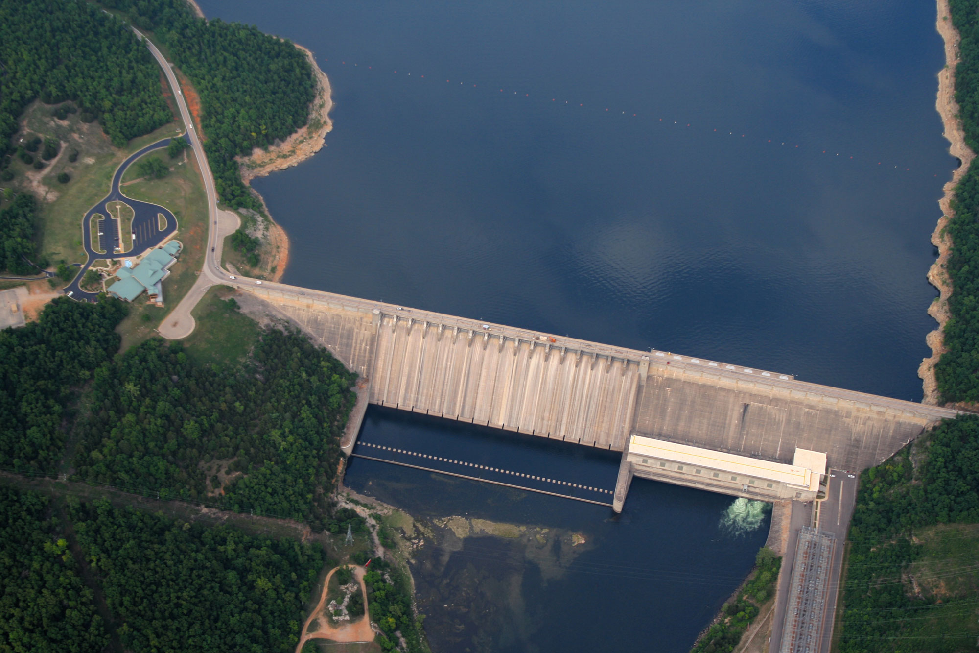 Aerial photograph of Bull Shoals hydroelectric dam on the White River in Arkansas. The photo shows a concrete dam holding back water on a river.