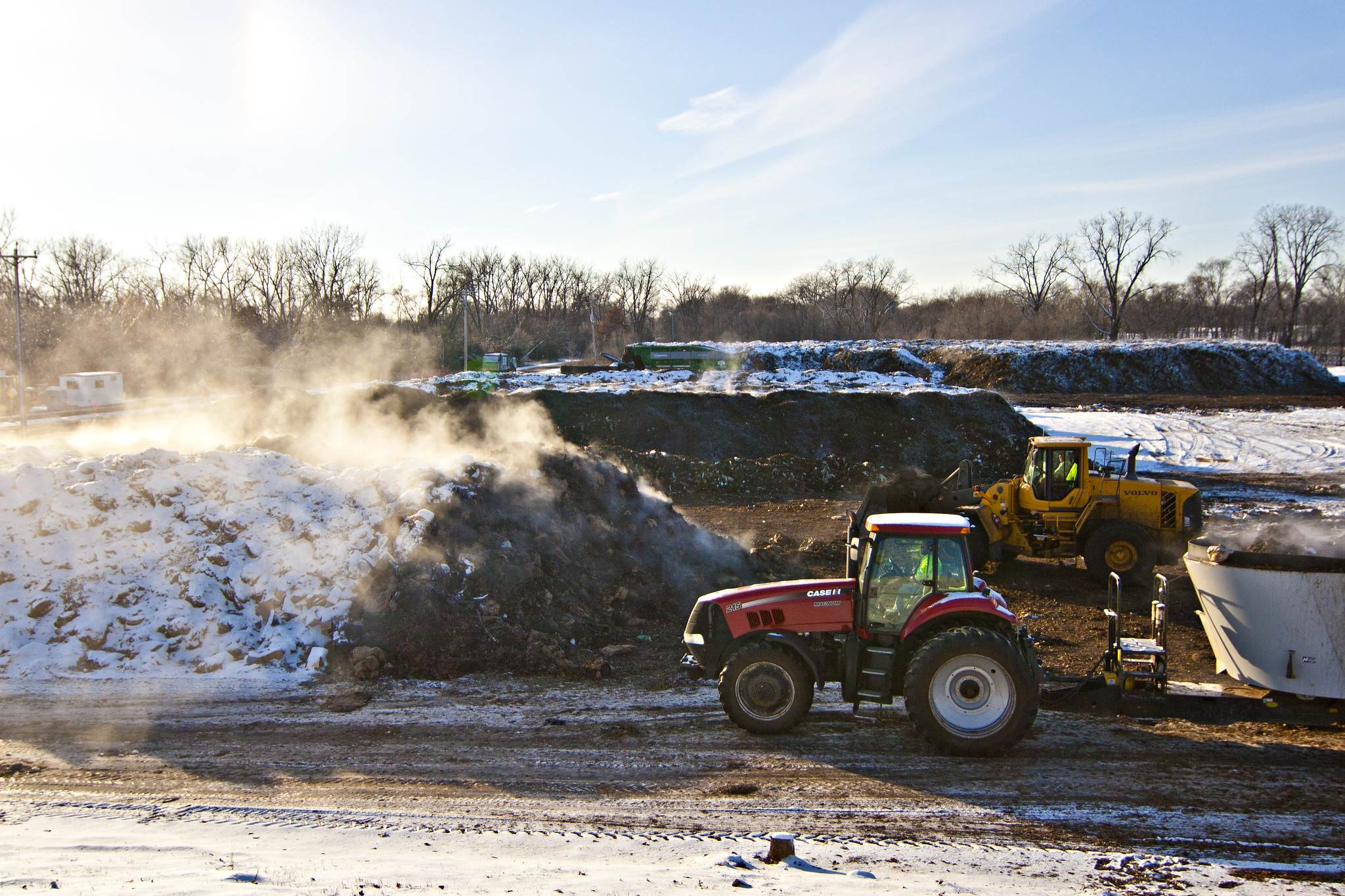 Photo of a commercial composting facility in Minnesota, showing steam rising from the compost in winter.