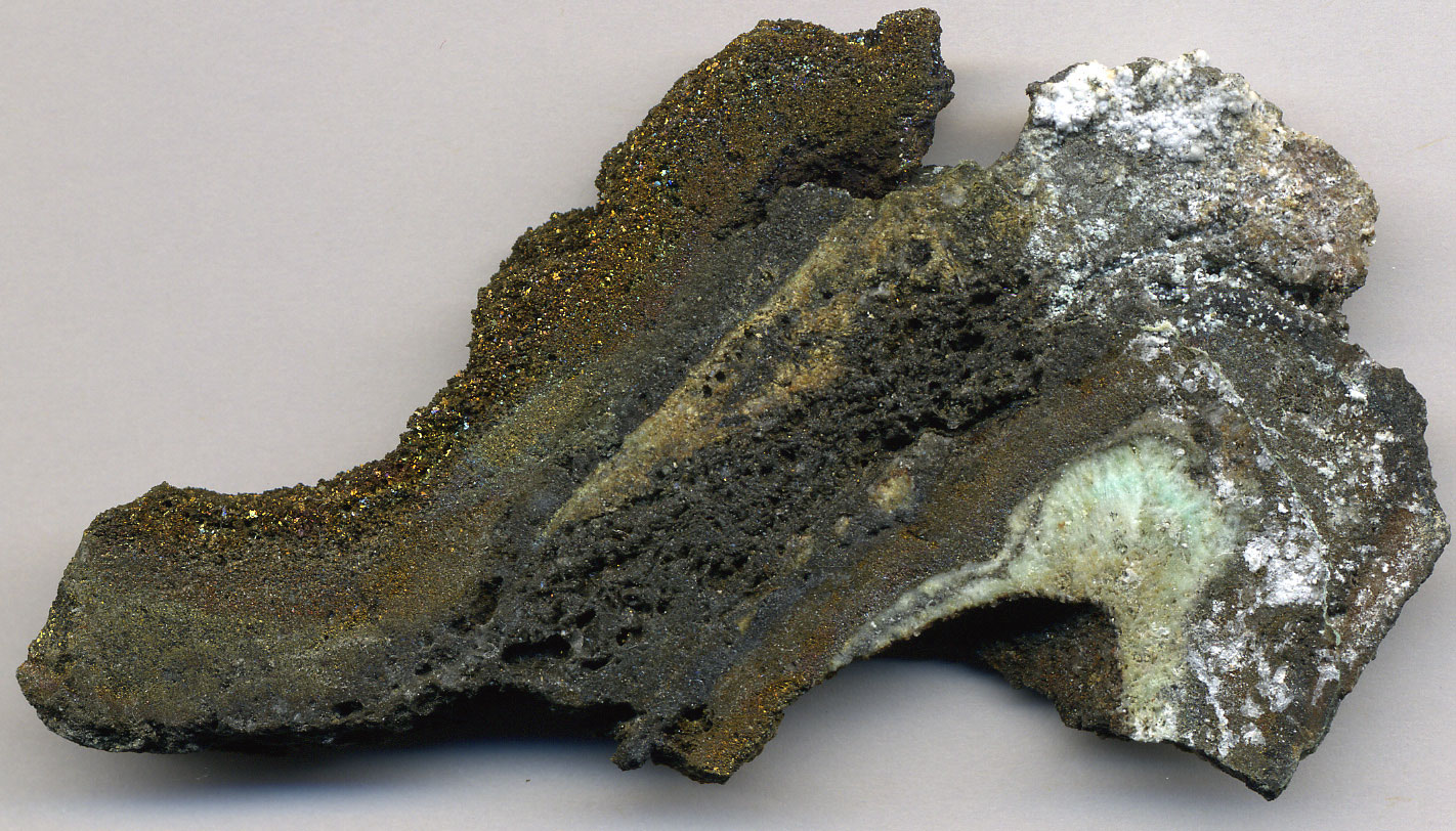 Photo of a rock from a black smoker, a type of hydrothermal vent, in the East Pacific Rise. The rock is mostly dark in color.