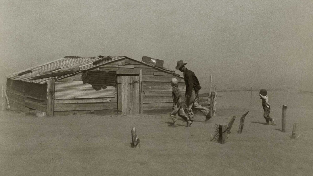 Photograph of a father walking with his two sons in the middle of a dust storm striking Oklahoma in 1936.