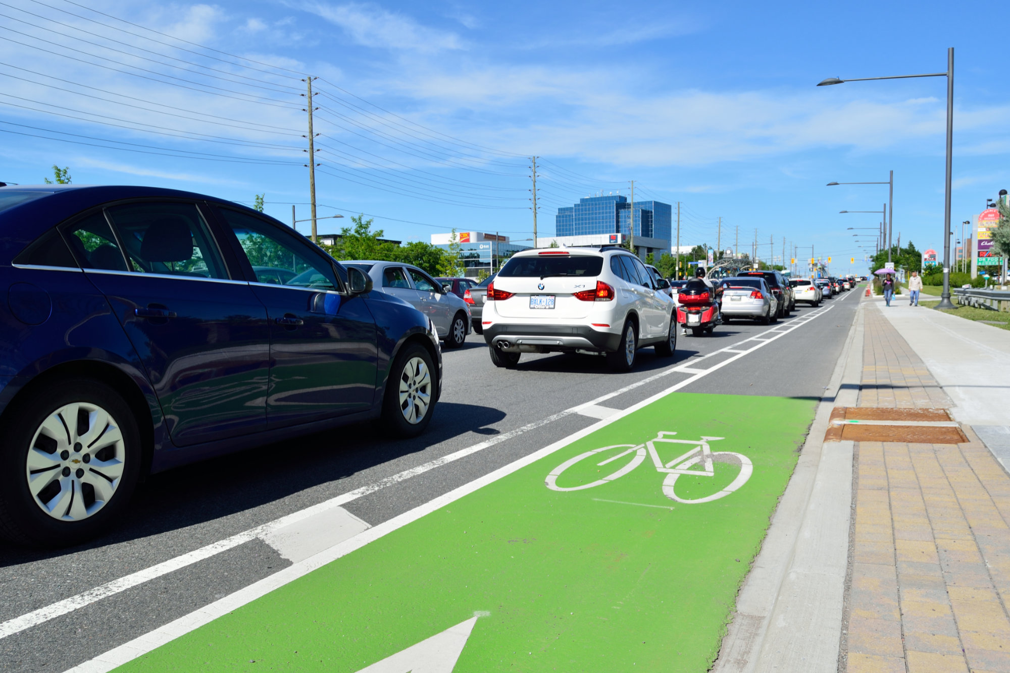 Photo showing a bike lane next to a road filled with cars.