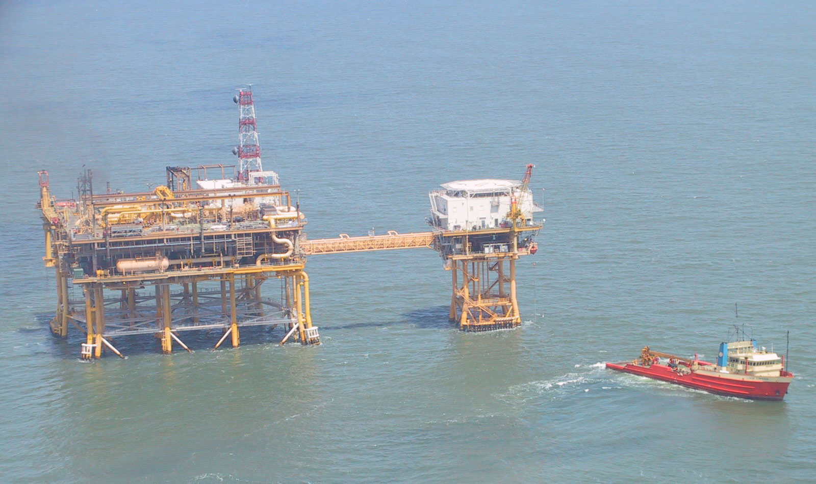 Photograph of the Louisiana Offshore Oil Port (LOOP) offshore pumping platform, a platform on stilts to lift it above the water. A ship is in the water nearby.