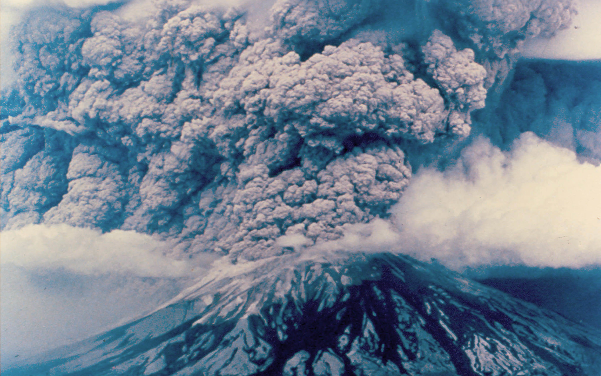 Photograph showing the explosive eruption of Mount St. Helens in 1980. Smoke spews from the mountaintop.