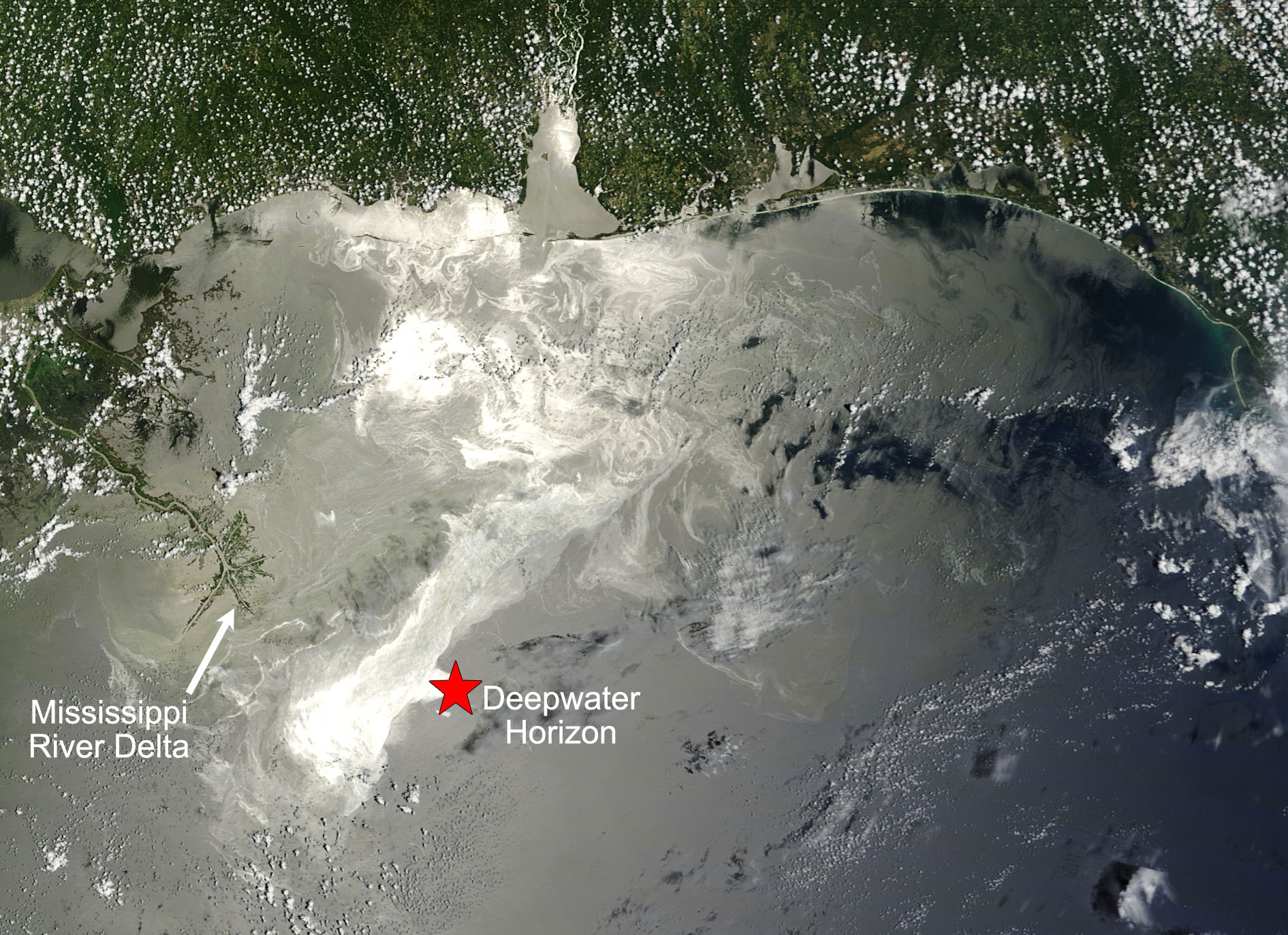 Satellite photograph of the Gulf of Mexico in 2010 showing an oil slick produced by the Deepwater Horizon disaster. The Mississippi River Delta is at the center-left of the image, with a star marking the approximate location of the Deepwater Horizon to the southeast.