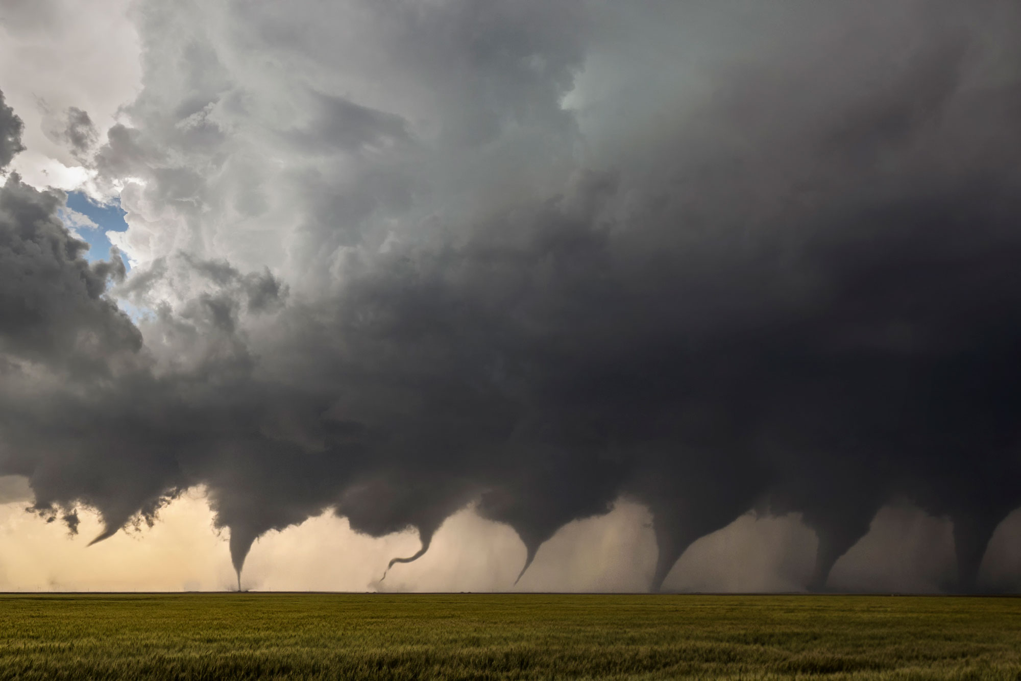 Photomontage of a tornado forming in a field and touching down on the ground north of Minneola, Kansas.