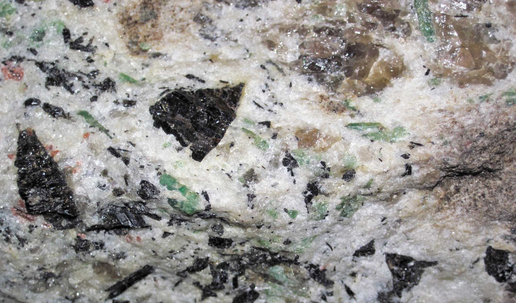 Photograph of small emeralds in a sample of pegmatitic granite from North Carolina.