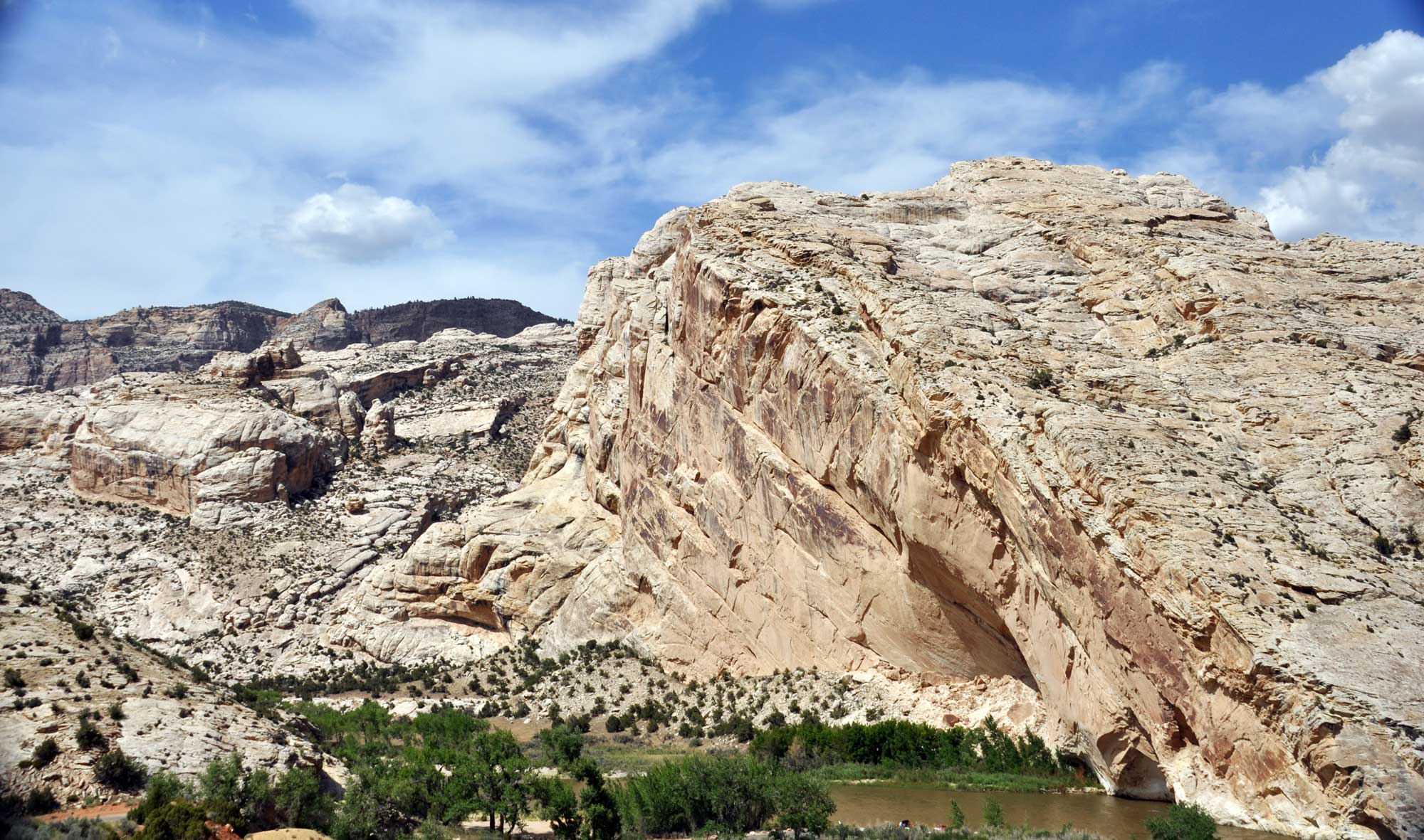 Photo of an outcropping of Weber Sandstone in Utah. The sandstone is beige in color and forms a sloping hill in the foreground.