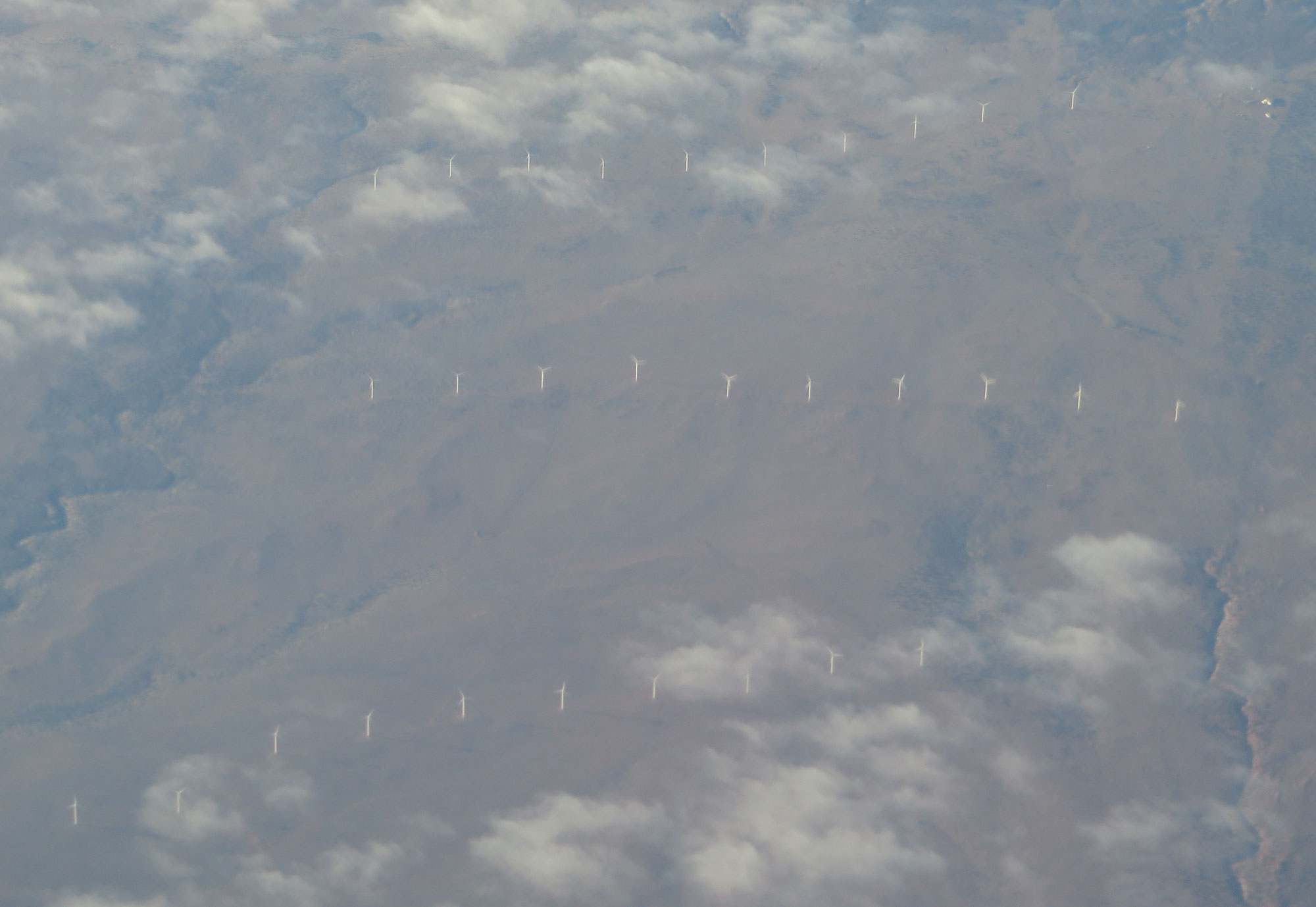 Aerial photograph of white wind turbines scattered over the landscape in a zig-zag formation near Snowflake, Arizona.