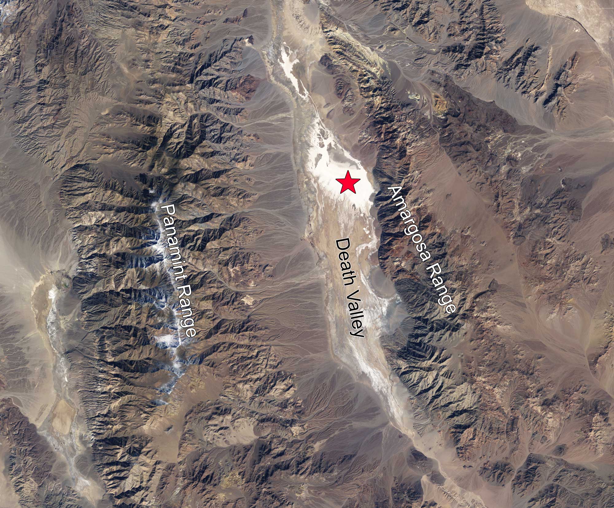 Satellite photo of Death Valley, California. The photo shows the valley running vertically from the top to the bottom of the image, with the Panamint Range to the west and the Amargosa Range to the east. The Badwater Basin, the lowest region in Death Valley, is marked with a red star.