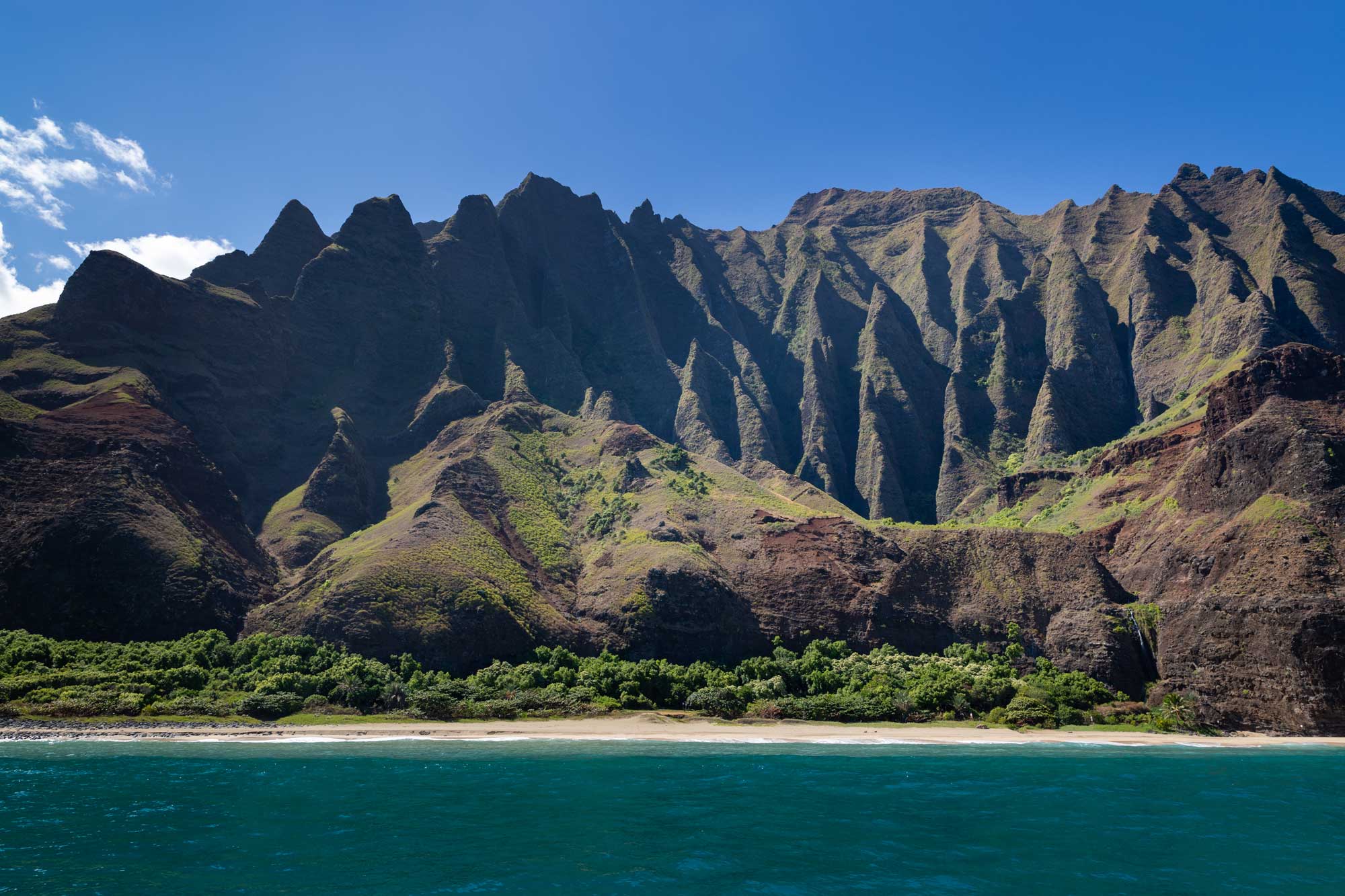 Photograph of the coast of Kaua'i showing deeply eroded, steep cliffs.