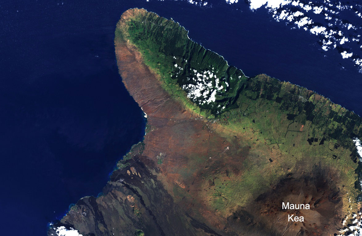 Satellite photo of the northern tip of the Big Island of Hawaii. The summit of Mauna Kea is visible in the lower right of the image. The east (right) slopes of the island are green and vegetated and the west (left) slopes are brown and dry. The summit of Mauna Kea is also brown and dry.