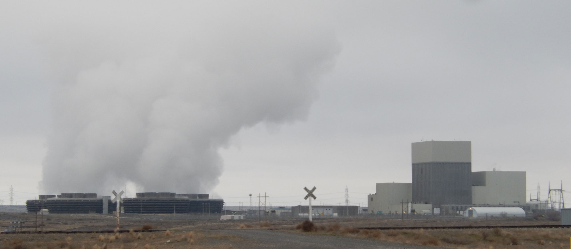 Photograph of Columbia Generating Station, a nuclear power plant is Washington. The photograph shows clouds of steam rising on the left, behind structures of the plant.