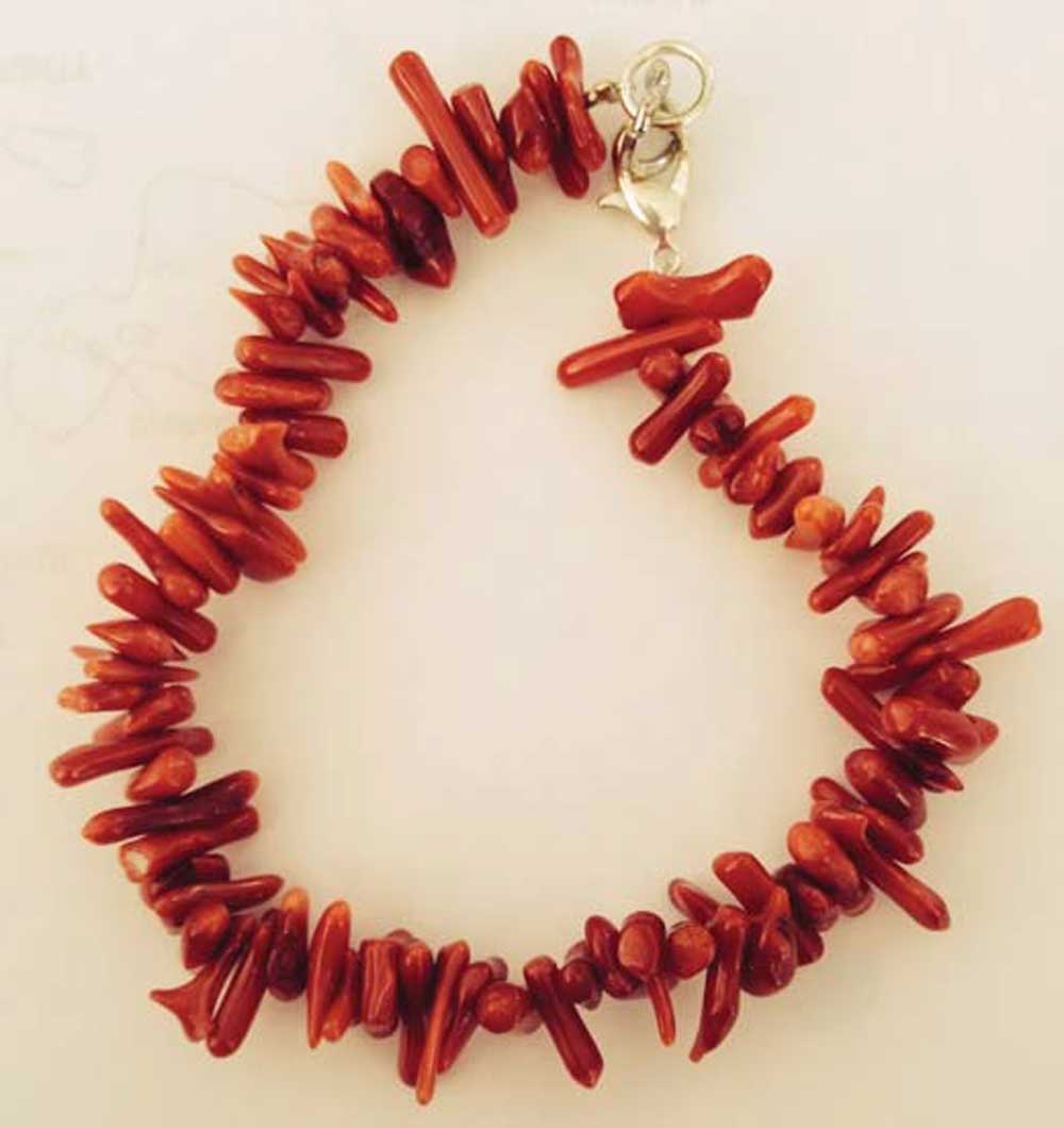 Photograph of a bracelet made from red-colored coral.