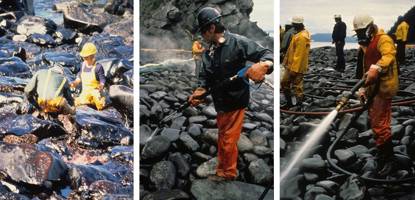 3-panel image showing people cleaning up rocks covered with oil on Alaska's coastline as a result of the Exxon Valdez oil spill. Panel 1: Two people kneeling on rocks and scrubbing them by hand. Both people are wearing yellow rubber overalls. Panel 2: A man wearing a black hardhat, black raincoat, and orange waterproof pants cleaning rocks with a sprayer. Panel 3: Man wearing a hardhat, a respirator, a raincoat, and waterproof pants and shoes cleaning rocks with a sprayer. In the background, other men stand around wearing white hardhats.