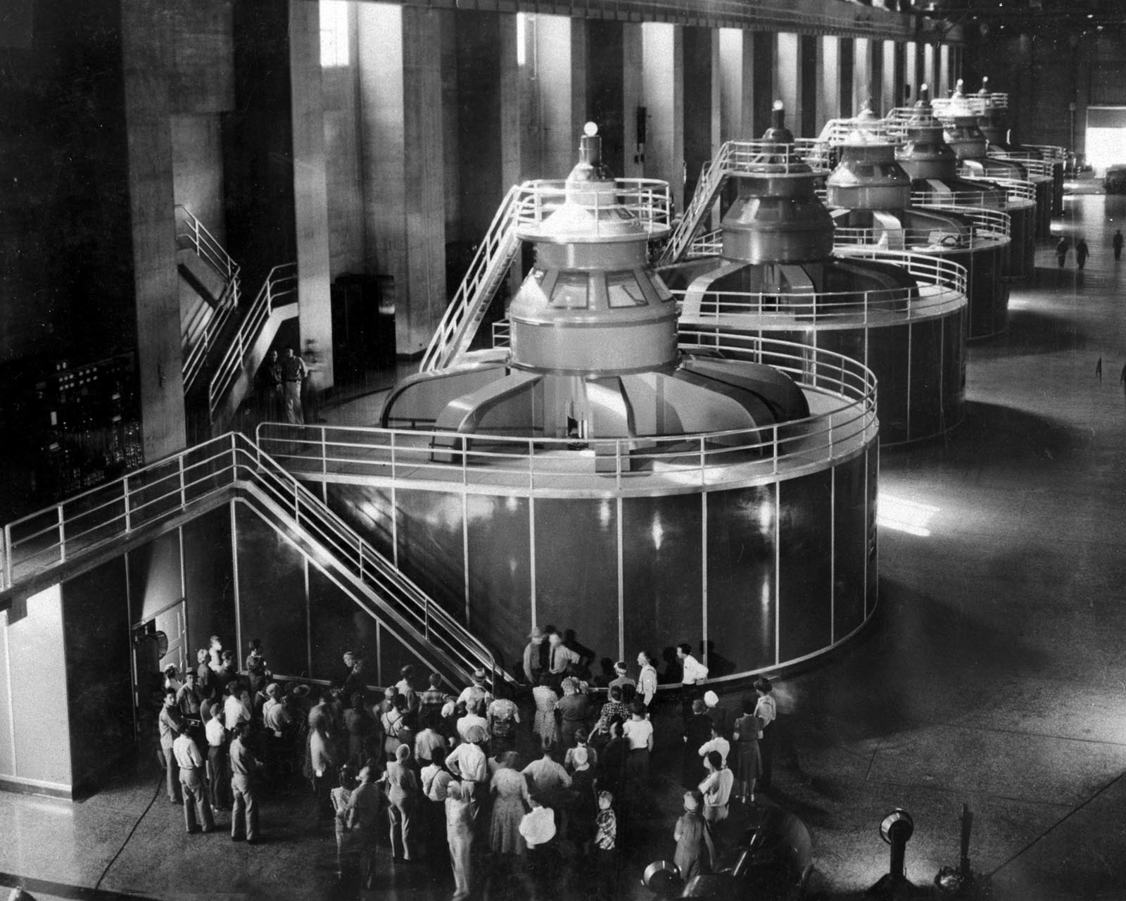 Black and white photograph of tourists in the Hoover Dam powerhouse in 1940. 