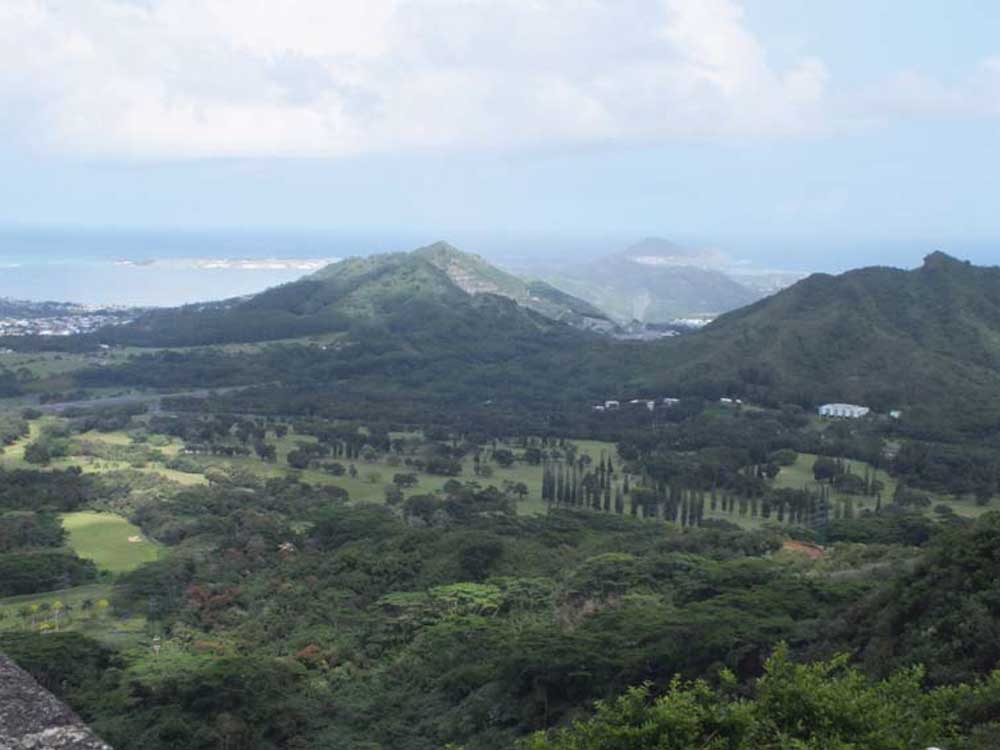 Photograph of hills on Oahu, Hawaii, one of which has a operating crusted stone quarry.