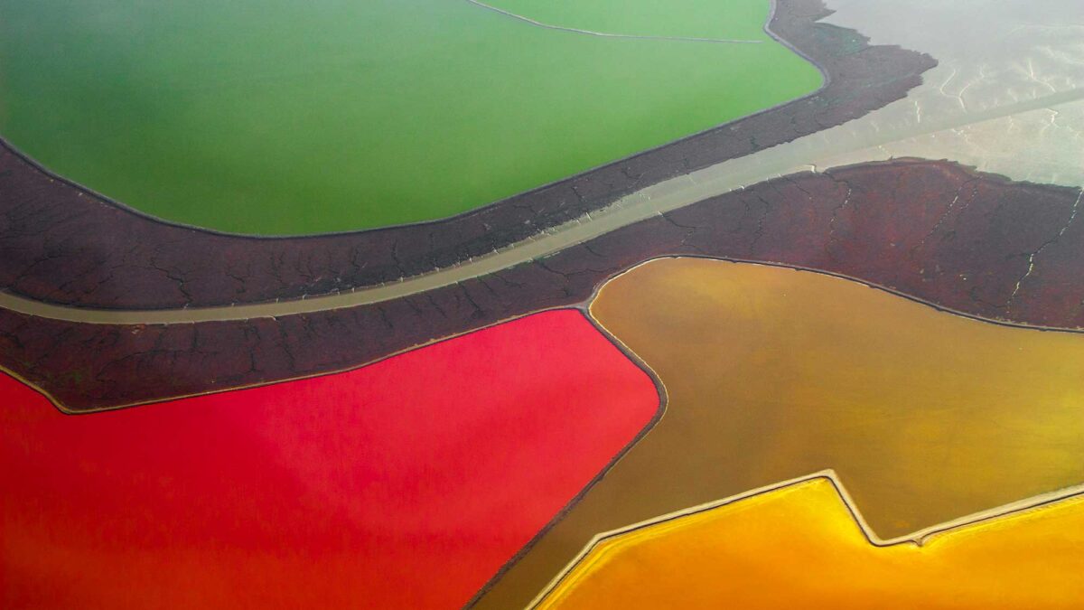 Aerial photograph of brightly-colored salt evaporation ponds in San Francisco Bay, California.