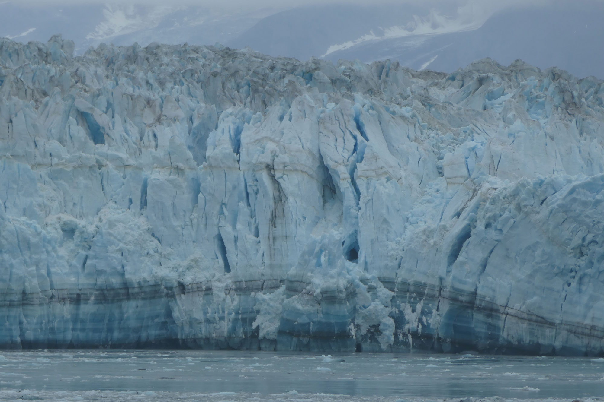 Photograph of Hubbard Glacier in Alaska showing chunks of ice calving into the ocean.