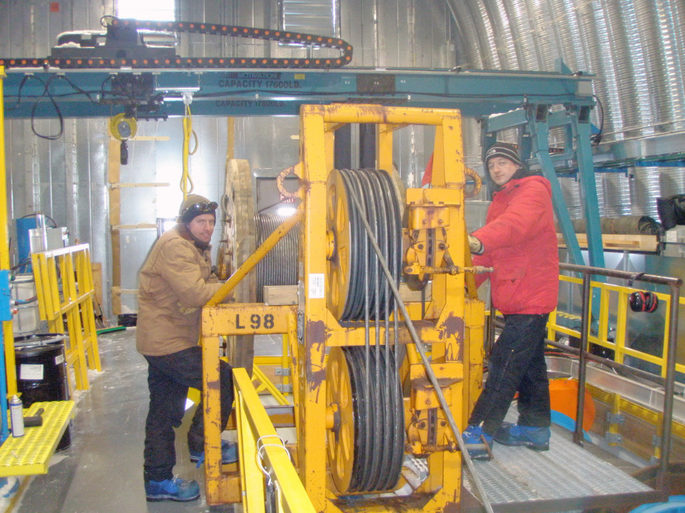 Photo of two people working on drilling ice cores in Antarctica