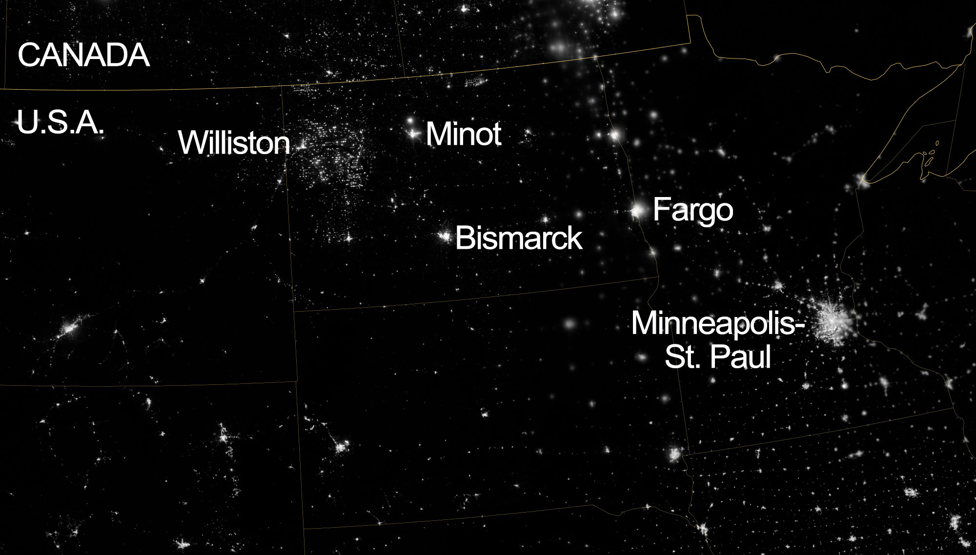 A nighttime satellite photograph of part of the north-central United States. Clusters of lights indicate the positions of cities. Labeled cities include Williston, Minot, Bismarck, and Fargo North Dakota and Minneapolis-St. Paul in Minnesota. A concentration of lights in the area near Williston indicates the intensity of oil and gas development in the Bakken Formation.
