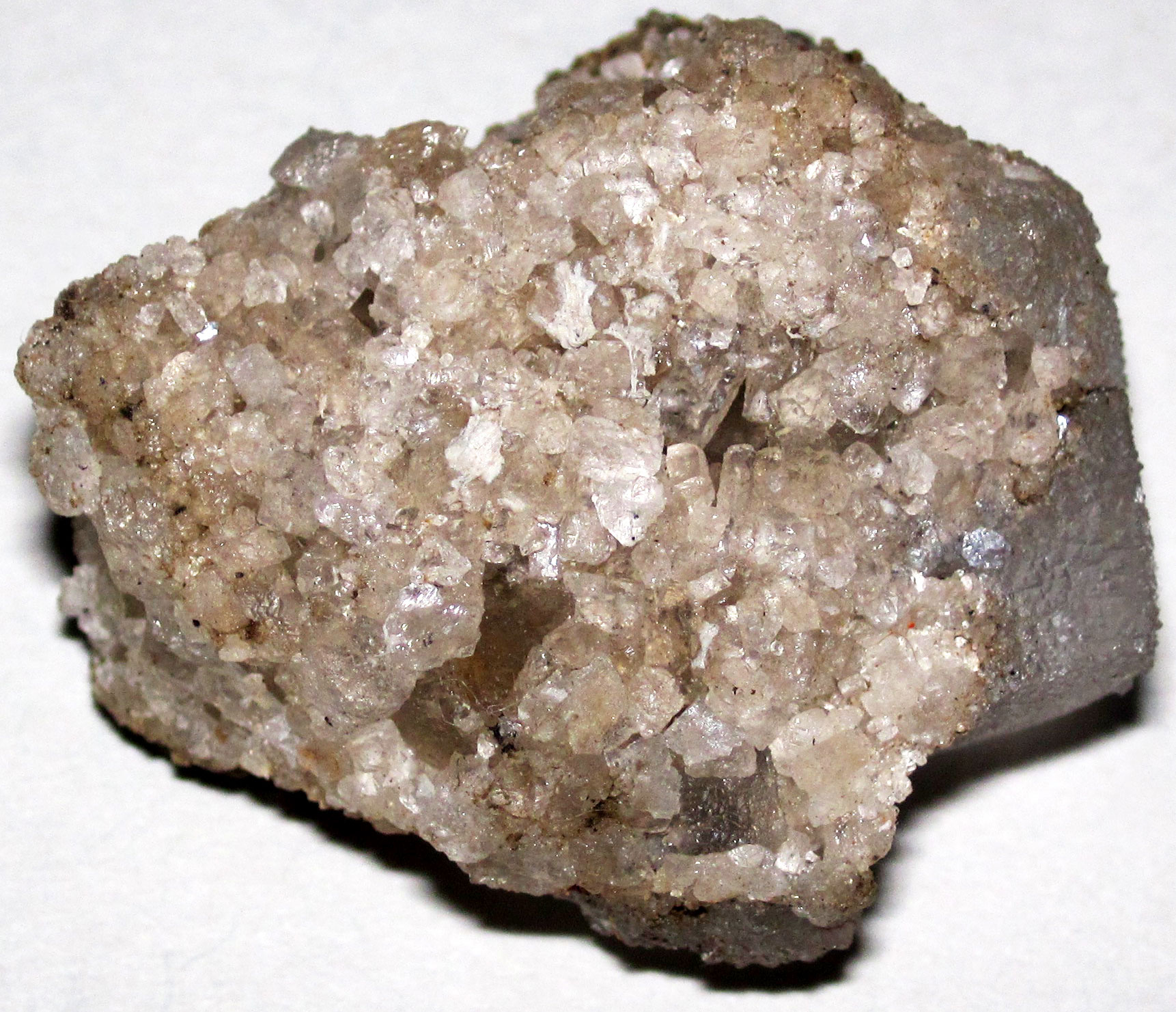 Photograph of Silurian rock salt from the Detroit Salt Company mine in Michigan. The photo shows a grayish rock covered with large yellowish to white crystals on its upper surface. 