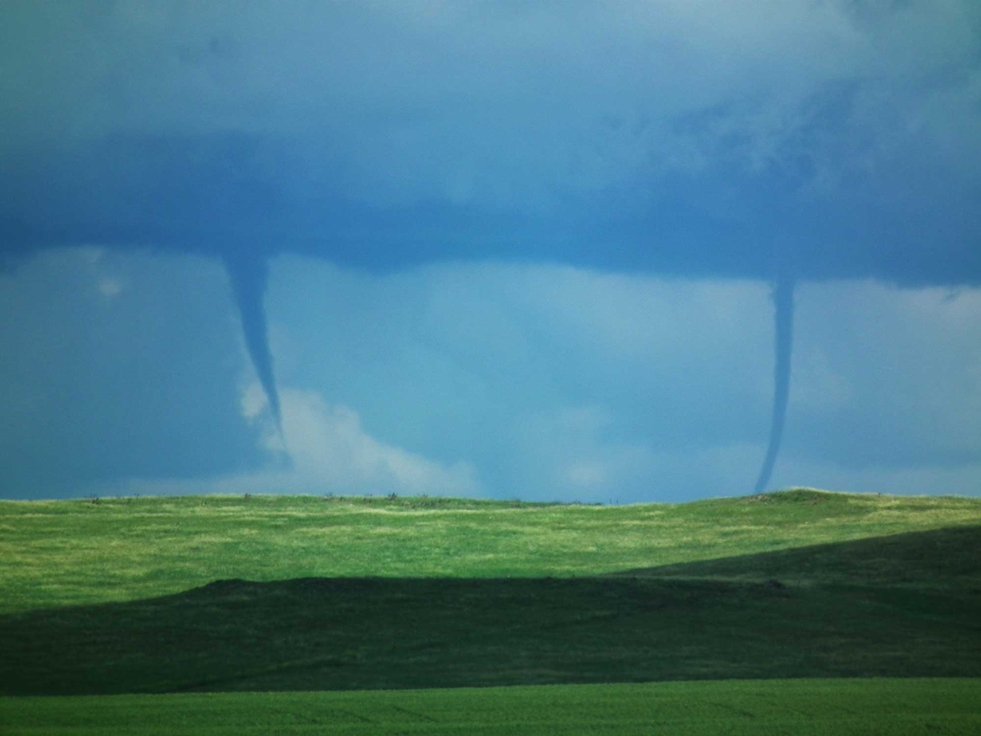 Photograph of two tornadoes touching down in a field at the same time in South Dakota.