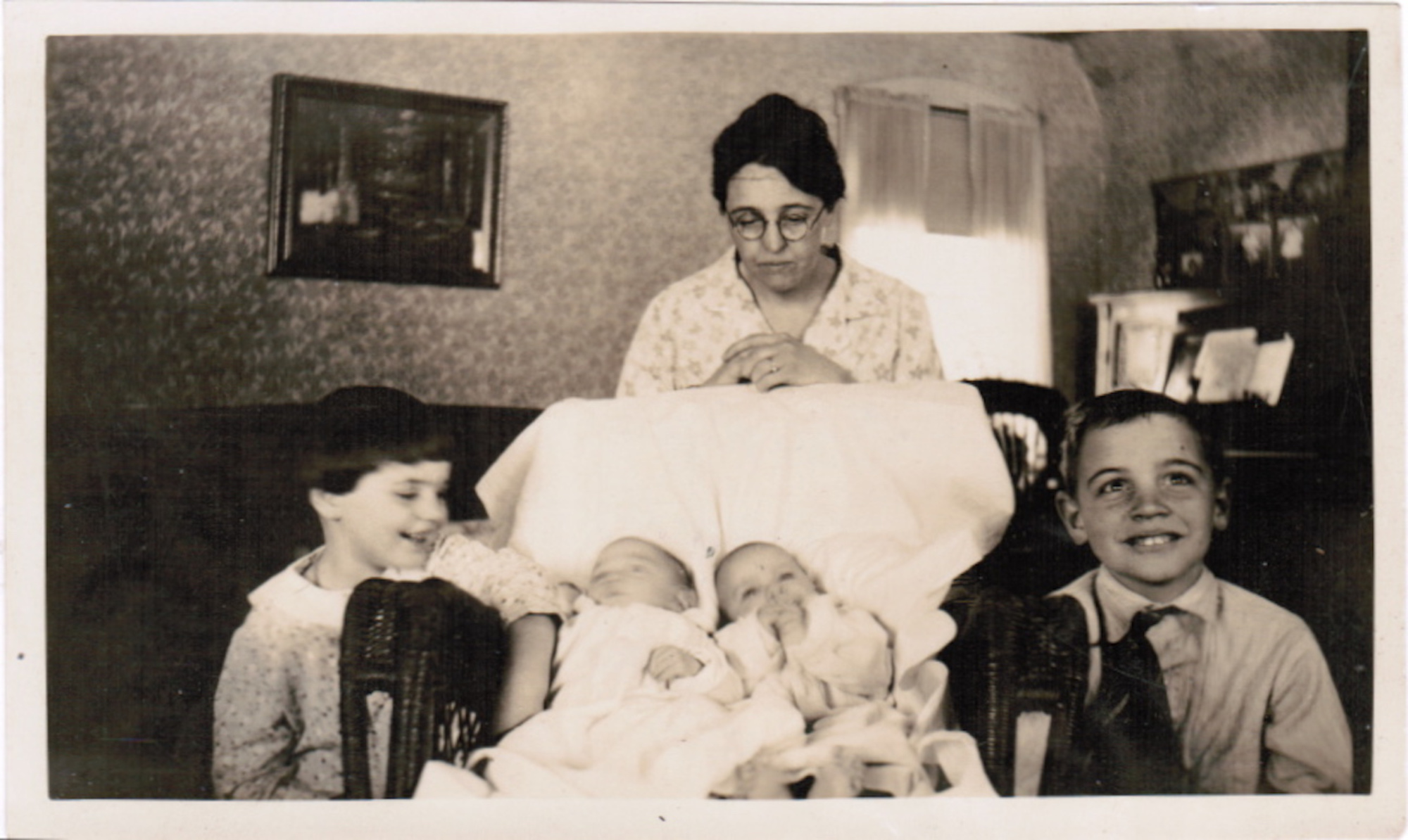 Old black and white photo of a woman and her children.