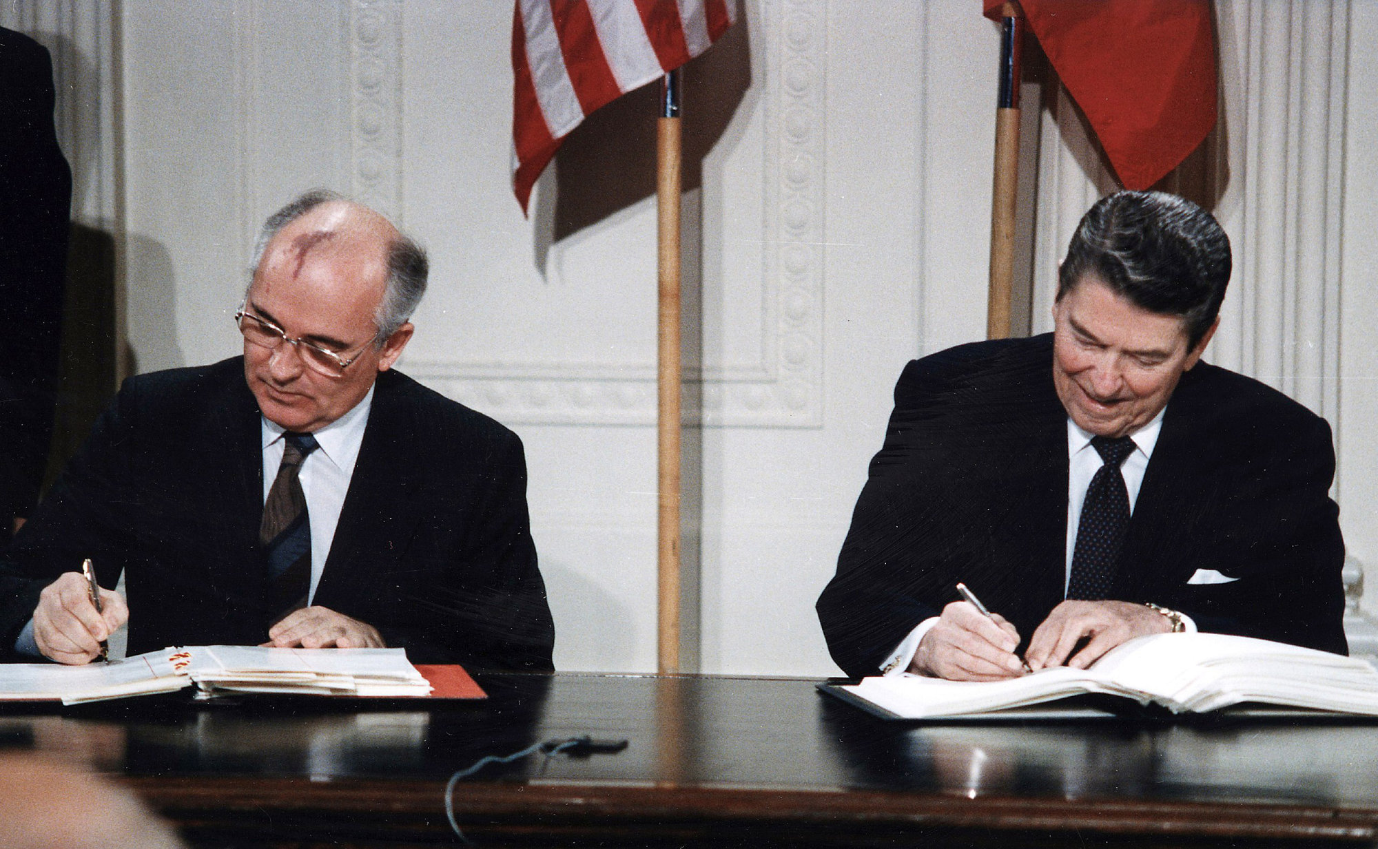 Photo of two world leaders signing an agreement.