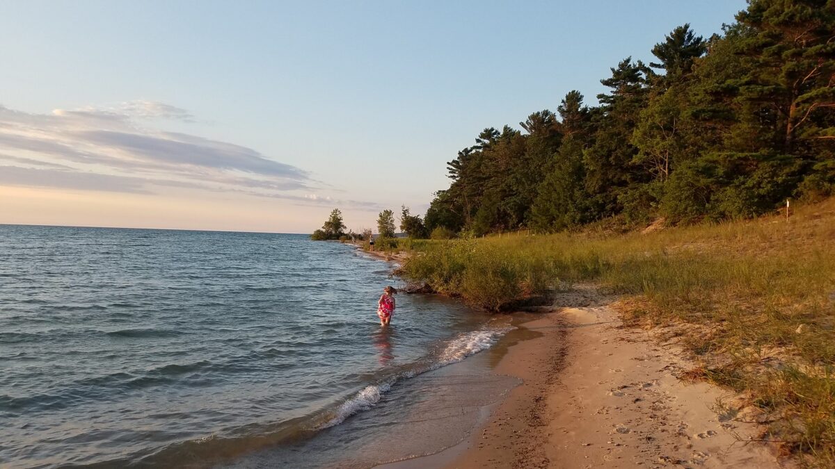 Photograph of a child at the beach in Michigan hunting for Petoskey stones.