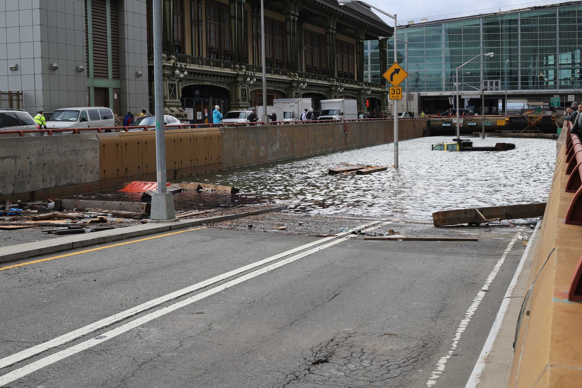 Photograph showing the flooded Battery Park Tunnel in Manhattan, New York City, following Hurricane Sandy in 2021. The photo shows the entrance to the tunnel completely blocked by standing water. The two-lane road disappears into the water.