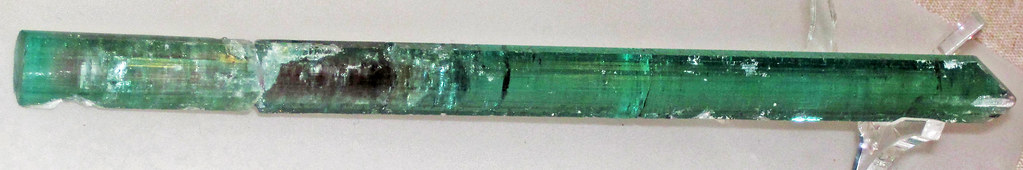 Photograph of a long crystal of elbaite tourmaline from Maine.