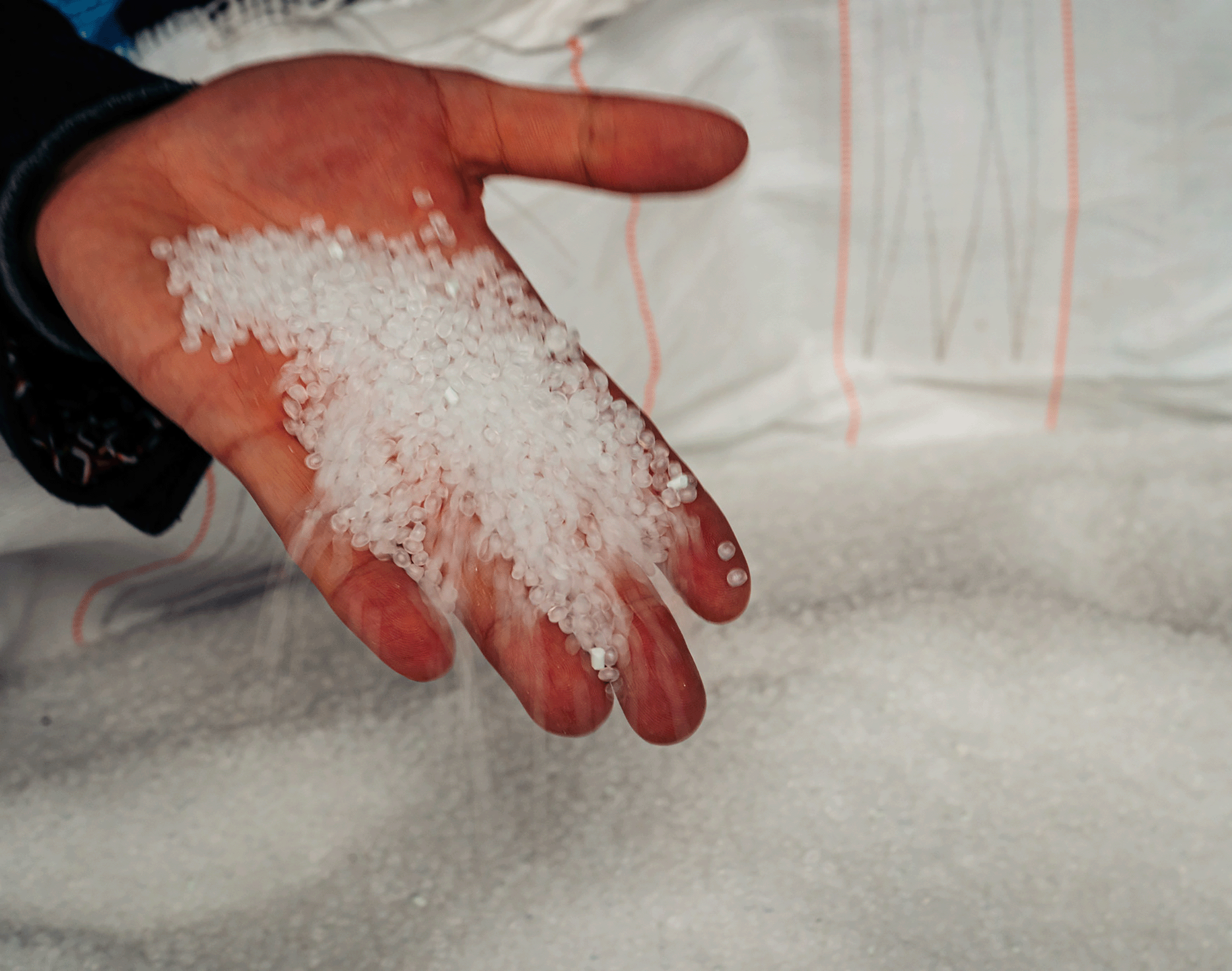 Photo showing a handful of tiny white plastic pellets.